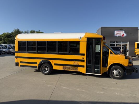 Yellow school bus parked in a lot beside a building with a 'Southern Bus & Mobility' sign and wheelchair accessibility icon in view.