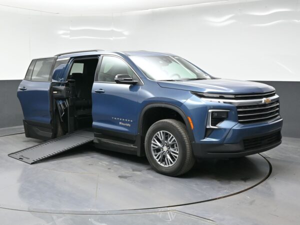 Blue Chevrolet Traverse SUV with the rear door open and a deployed wheelchair ramp extending from the vehicle. BraunAbility logo visible on the side panel.