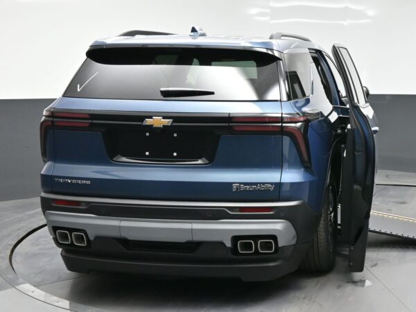 Blue Chevrolet Traverse viewed from the rear with BraunAbility branding, showing an open side door on the passenger side and quad exhausts; accessible vehicle convert.