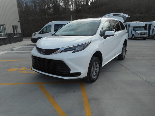 DSCN3738 White Toyota minivan with rear hatch open in a parking lot, surrounded by other white vans.
