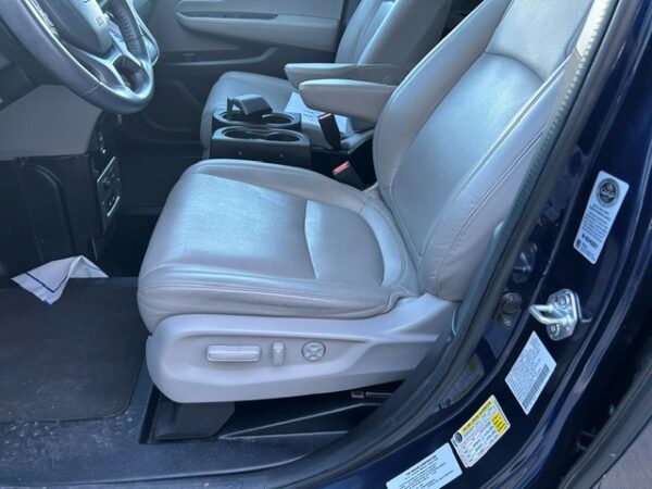 Driver's seat Interior of a vehicle showing the driver's seat with light gray leather, center console, and steering wheel.