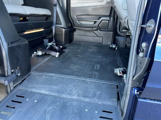 Wheelchair-accessible van interior with a lowered floor, wide open space, and wheelchair tie-downs along the sides.