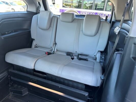 Three gray captain-style seats in the rear cargo area with headrests and seatbelts visible in a minivan interior