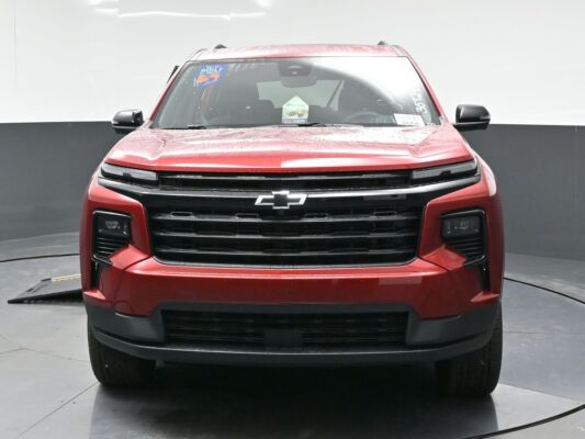 Front view of a red Chevrolet pickup/SUV with a black grille and chrome bowtie emblem. (Rain droplets on the hood)