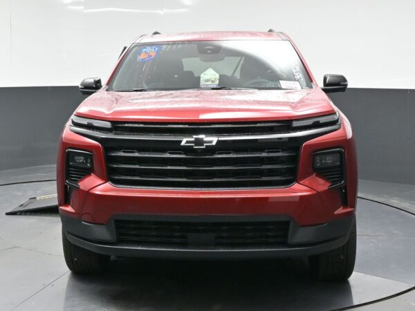 Front view of a red Chevrolet pickup/SUV with a black grille and chrome bowtie emblem. (Rain droplets on the hood)