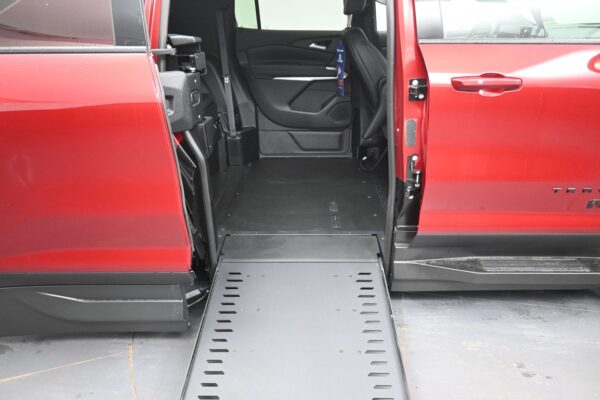 Red van with the side door open and a lowered ramp extending into the interior, ready for wheelchair access.