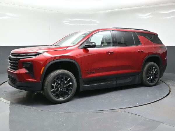 Red SUV (Chevrolet Trailblazer) on a turning display platform in a studio, glossy black wheels and black trim visible, side badges readable.