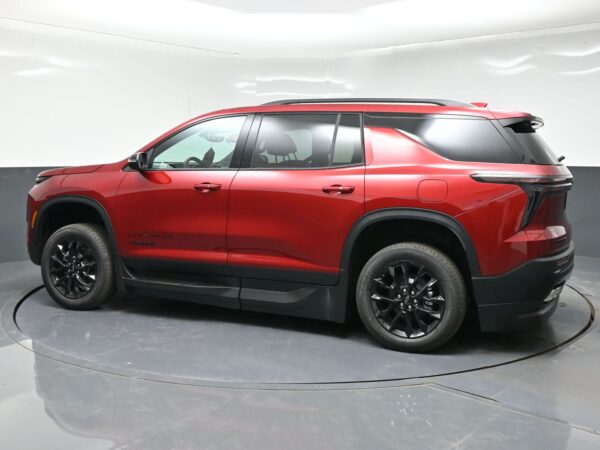 Side view of a red SUV with black wheels parked in a studio backdrop, showing roof rails and tinted windows.