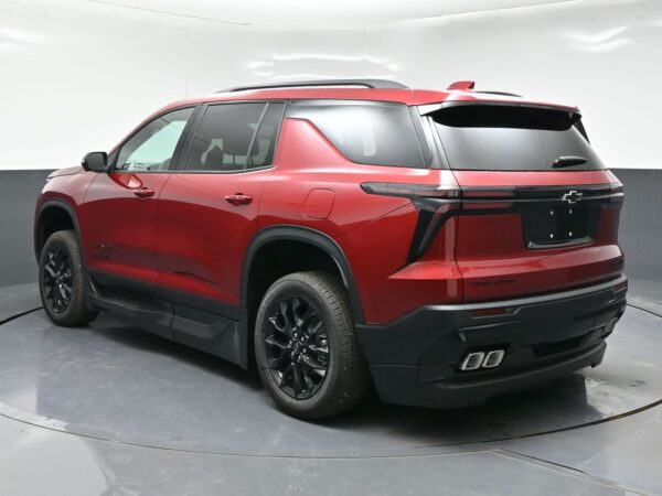 Red Chevrolet Tahoe SUV shown from the rear-left side, highlighting black wheels, roof rails, and sculpted rear end with dual exhausts