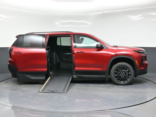 Red minivan with a lowered side ramp for wheelchair access and doors open, showing the interior seating area.