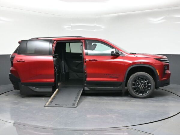 Red minivan with a lowered side ramp for wheelchair access and doors open, showing the interior seating area.