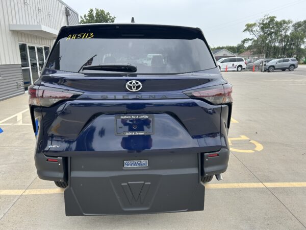 IMG_4983 Rear of a dark blue Toyota Sienna in a parking lot, with a Vantage Mobility license plate frame visible.
