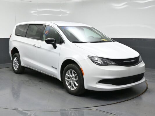 White Chrysler Pacifica minivan in a studio setting, angled to show front and passenger side.