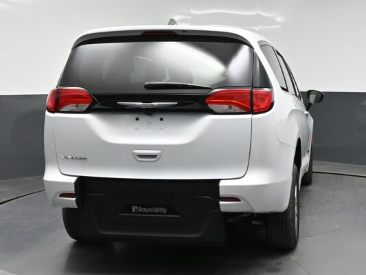 Rear view of a white Chrysler Voyager BraunAbility minivan, showing the tailgate, red taillights, and rear wiper.