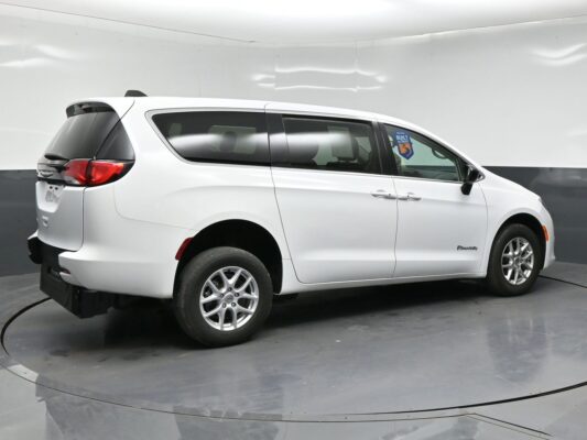 White wheelchair-accessible minivan shown from the side/rear angle with BraunAbility branding on the side door area