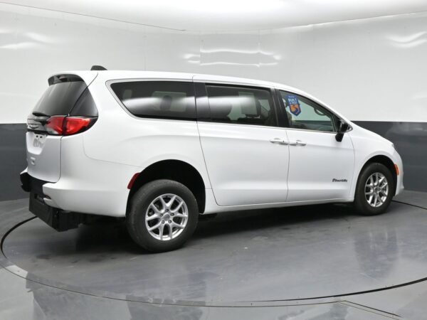 wav-2C4RC1CGXRR118735-6 White wheelchair-accessible minivan shown from the side/rear angle with BraunAbility branding on the side door area
