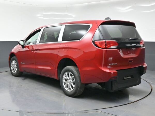 Red Chrysler Voyager minivan shown from the rear three-quarter view in a showroom lighted studio.