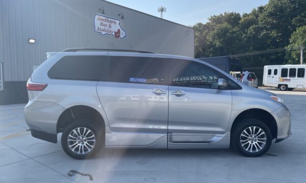 IMG_0403 Silver minivan parked outside a building with a Southern Bus & Mobility sign; appears to be a mobility/conversion van viewed from the side