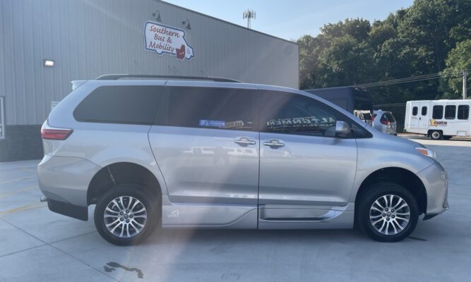 Silver minivan parked outside a building with a Southern Bus & Mobility sign; appears to be a mobility/conversion van viewed from the side