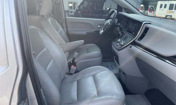 IMG_0409 Interior of a vehicle showing light gray leather front seats, steering wheel, and center console.