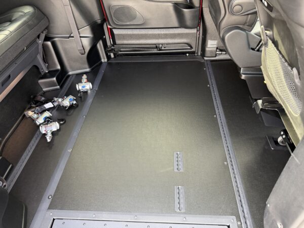 IMG_3475 Cargo area of a car with rear seats folded, dark loading floor, and keys scattered on the left side.