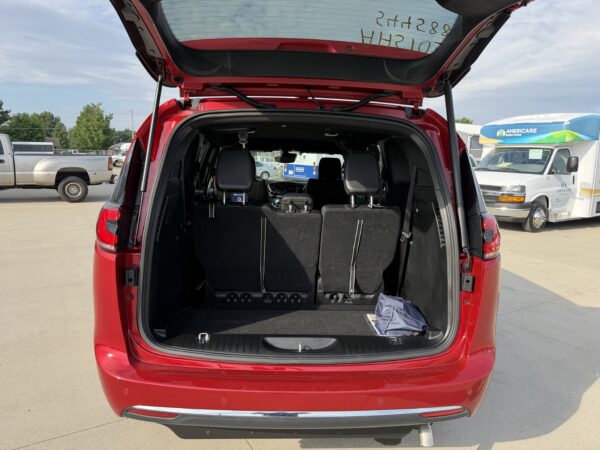 IMG_3477 Red SUV with rear hatch open, showing folded third-row seats and cargo space in the back.