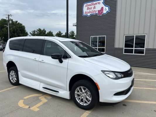 White van parked in a handicap space in front of a building with a Southern Bus & Mobility sign on the wall outside.