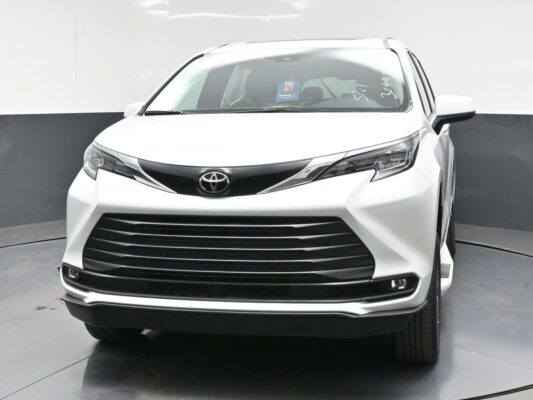 Front view of a white Toyota SUV facing the camera, highlighting the bold black grille and sleek headlights in a studio setting.