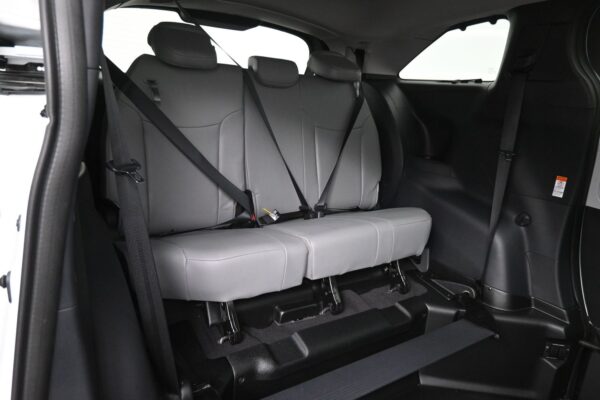 Three-seat rear row in a car with gray upholstery and three-point seat belts, seen from the side.