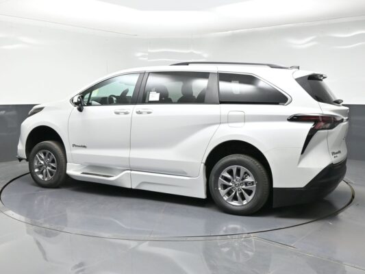White BraunAbility accessible minivan shown in a side view, in a studio setting.