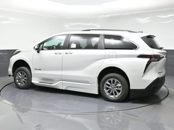 White BraunAbility accessible minivan shown in a side view, in a studio setting.