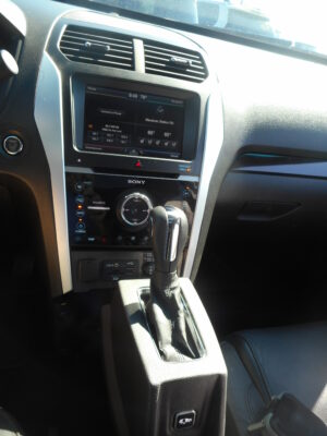 Car interior center console with a touchscreen infotainment system and gear shifter visible in the foreground