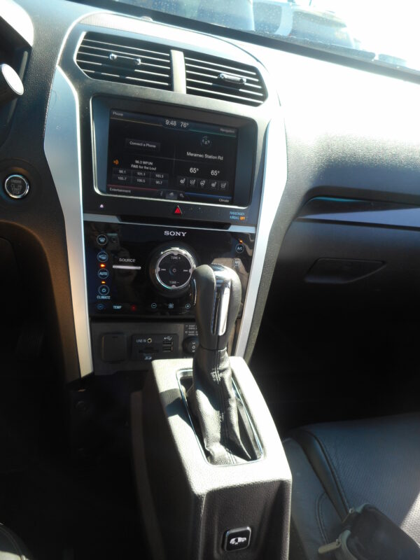 Car interior center console with a touchscreen infotainment system and gear shifter visible in the foreground