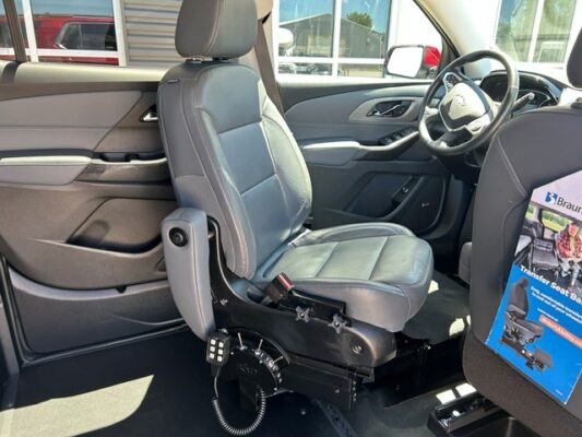 Wheelchair-accessible vehicle interior with a removable front seat and mobility base attached to the floor, showing seating for an accessible ride.
