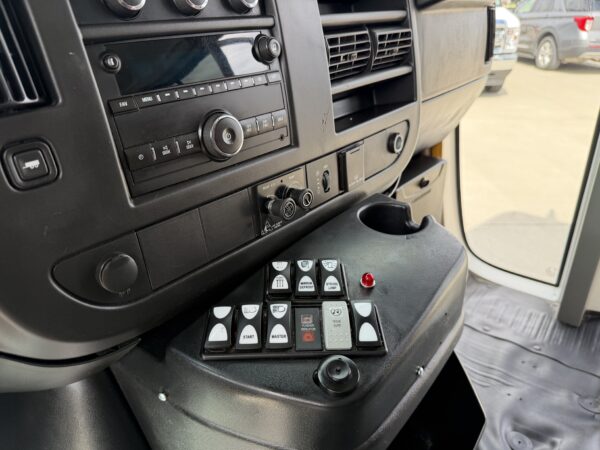 Center console of a truck cabin showing radio, climate controls, and numerous labeled buttons and switches