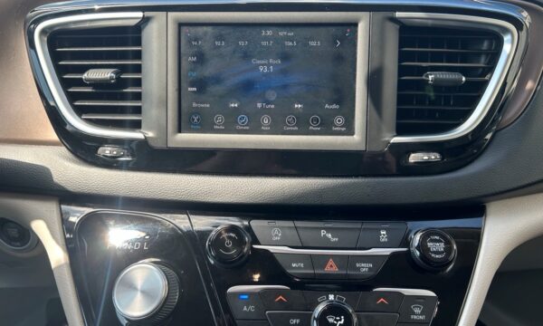 Center touchscreen car radio showing FM 93.1 Classic Rock, time 3:30, with climate and app controls below; air vents on both sides.