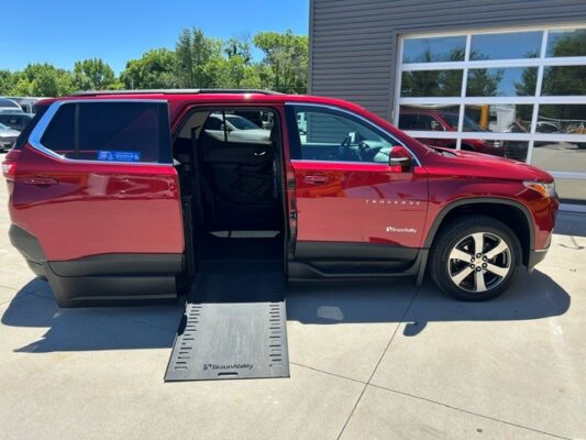 Red accessible minivan with a side-entry ramp deployed, doors open, BraunAbility ramp in view.