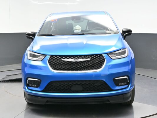 Front view of a blue SUV with a black honeycomb grille and angular LED headlights in a studio setting.