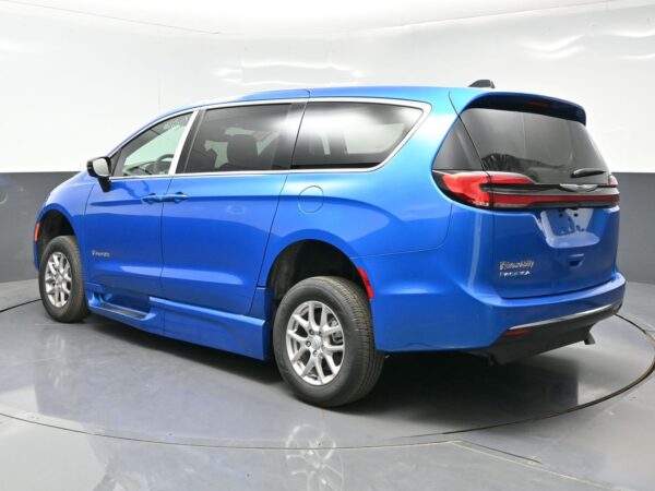 wav-2C4RC1BGXTR202255-4 Blue Chrysler Pacifica minivan photographed from rear three-quarter view in a studio, showing alloy wheels and chrome window trim.