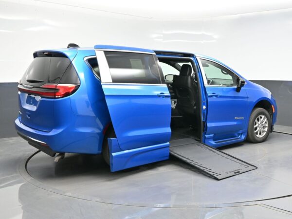 wav-2C4RC1BGXTR202255-6 Blue minivan with both side doors open and a deployed side ramp for wheelchair access.
