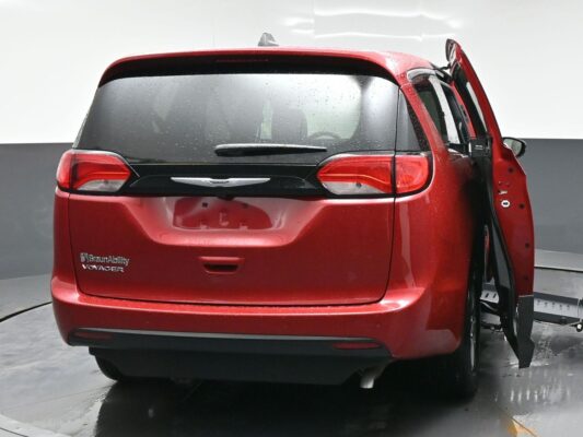 Rear view of a red BraunAbility Voyager minivan with the side-entry door open, highlighting wheelchair-accessible features.