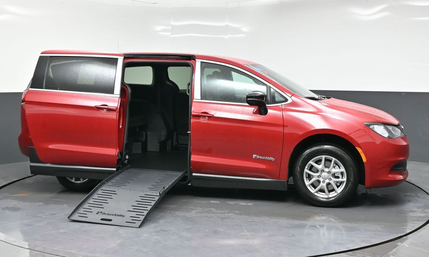 Red BraunAbility wheelchair-accessible minivan with the side ramp extended and the sliding door open.