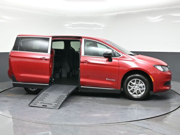 wav-2C4RC1CG9TR284610-7 Red BraunAbility wheelchair-accessible minivan with the side ramp extended and the sliding door open.