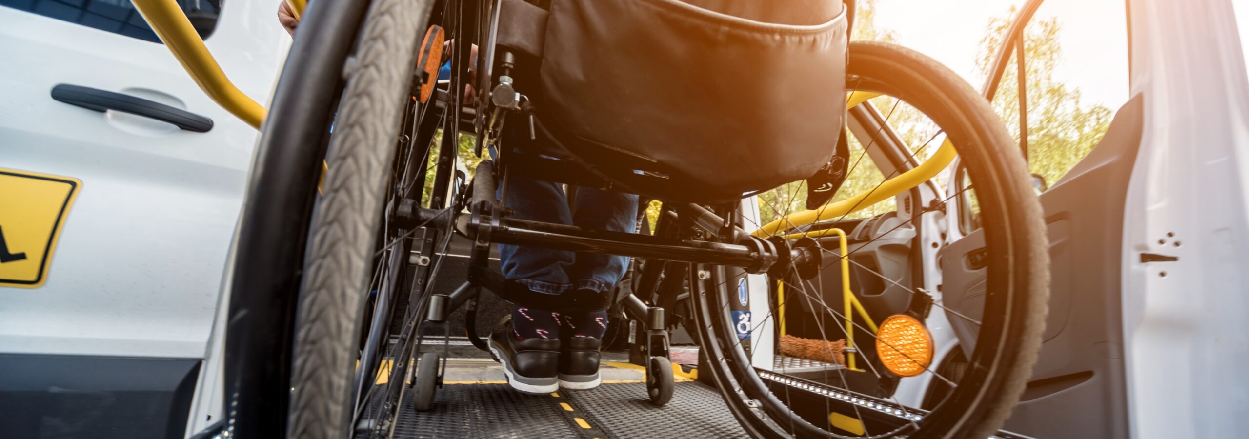 A man in a wheelchair on a ramp of a specialized vehicle for people with disabilities.