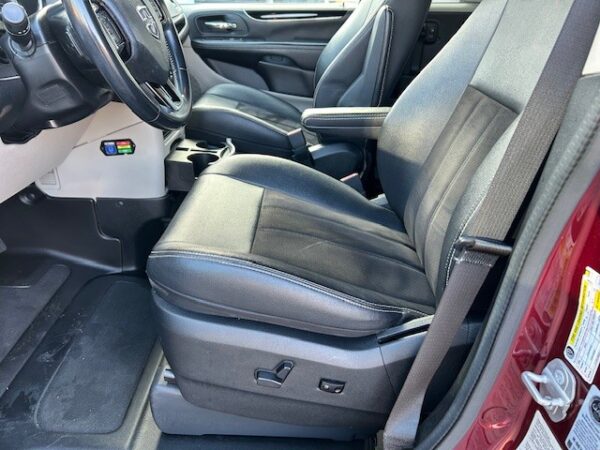 Driver's seat Front interior of a vehicle with black leather seats, steering wheel on the left, and a center console; visible seat adjustment controls on the side of the driver's seat.