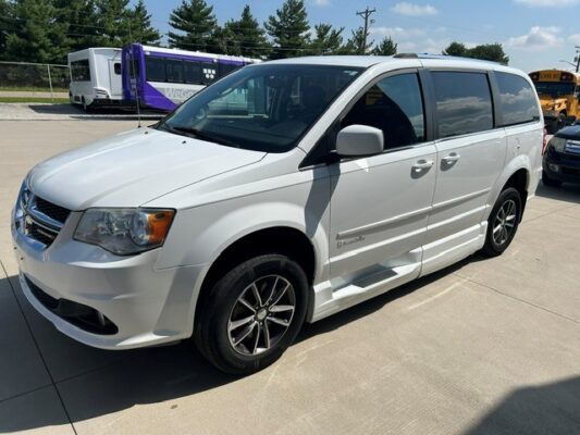 White Chrysler minivan parked in a lot, showing side and front angles; features include sliding doors and alloy wheels.