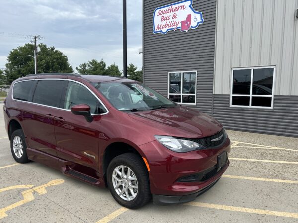 Maroon wheelchair-accessible van parked in a lot beside a grey metal building with a 'Southern Bus & Mobility' sign and handicap logo visible on the wall.