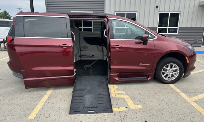 Maroon BraunAbility wheelchair-accessible minivan with ramp deployed and doors open in a parking lot