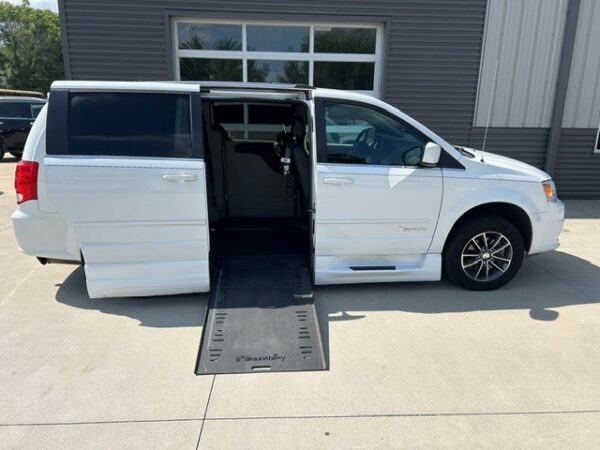 White wheelchair-accessible minivan with a side-entry ramp extended for loading a wheelchair.
