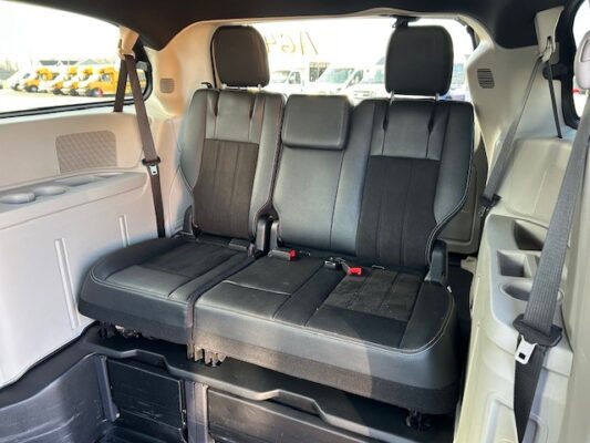 Three black leather seats in the back of an SUV, each with a headrest and visible seat belts